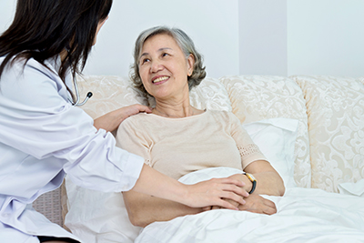 A doctor visits a patient in her hospital bed