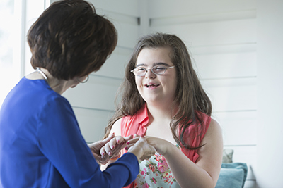 A smiling girl holds hands with her mother