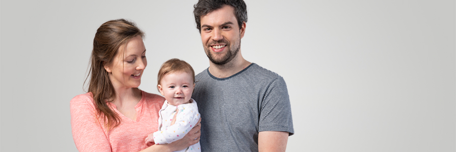 A smiling couple with a baby