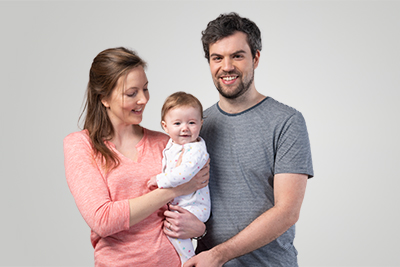 A smiling couple with a baby